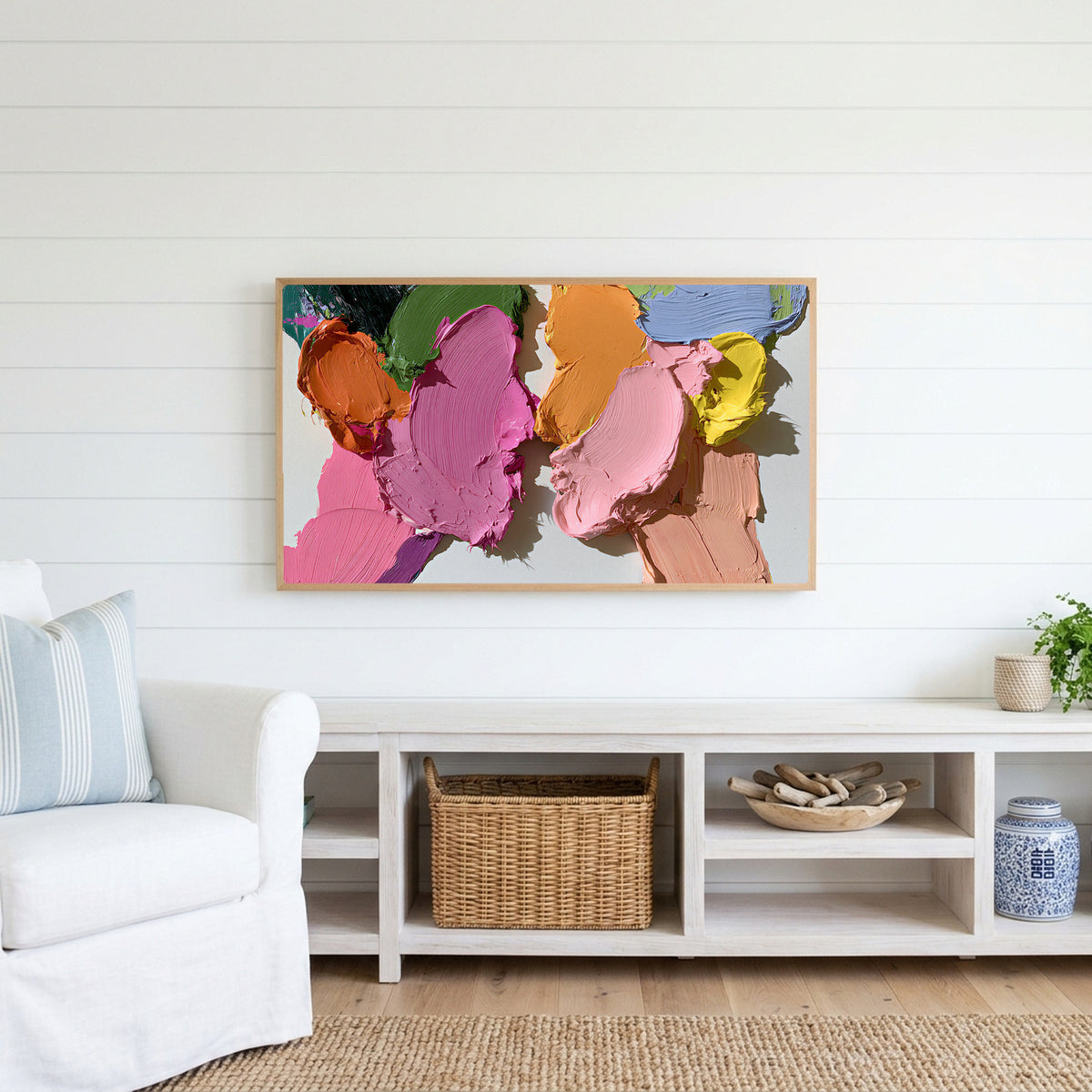 Pastel paint strokes Frame TV art above a white console with a rattan basket in a coastal living room