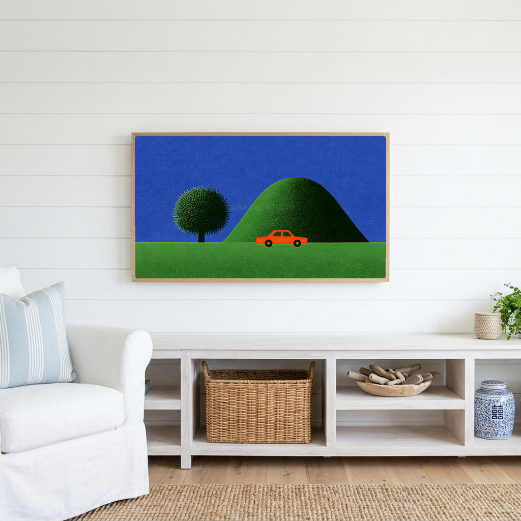 Red car by a green hill Frame TV art above a white console with a rattan basket in a coastal living room