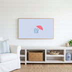 Umbrella kitten Frame TV art above a white console with a rattan basket in a coastal living room
