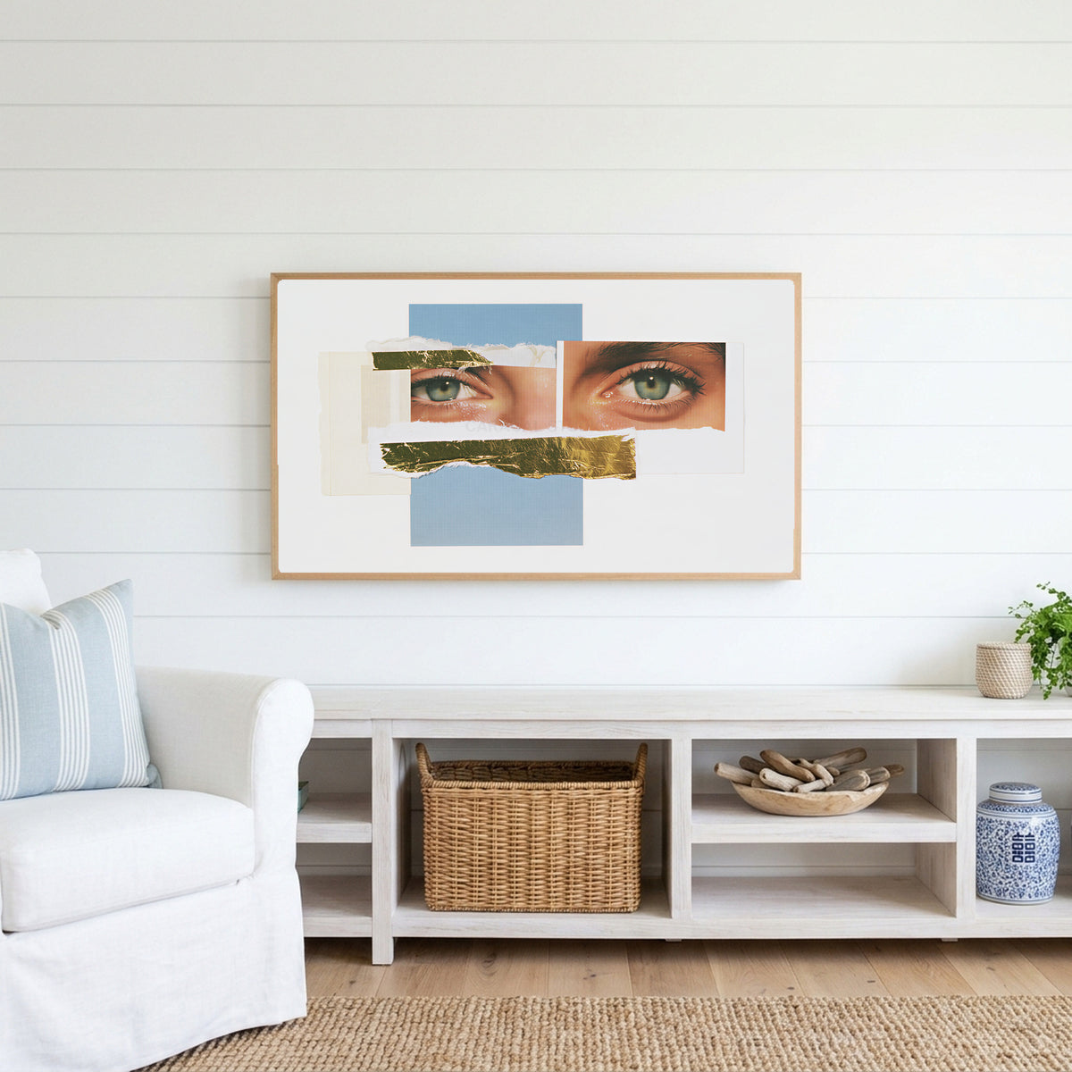 Eye collage Frame TV art above a white console with a rattan basket in a coastal living room