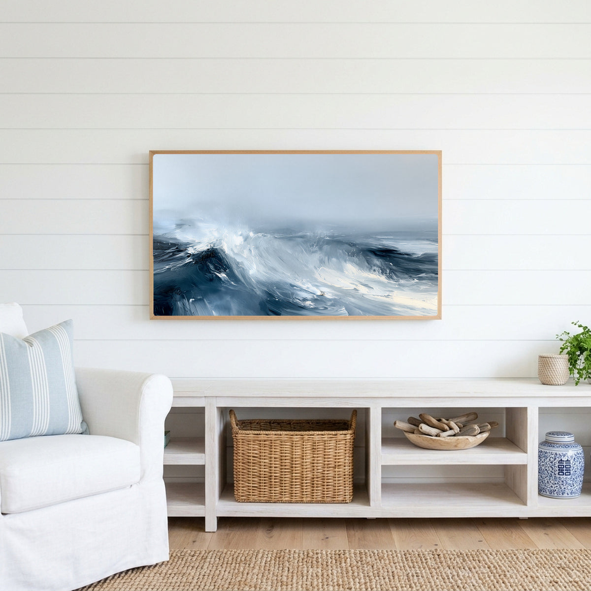 Ocean waves Frame TV art above a white console with a rattan basket in a coastal living room