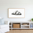 Croissant etching Frame TV art above a white console with a rattan basket in a coastal living room