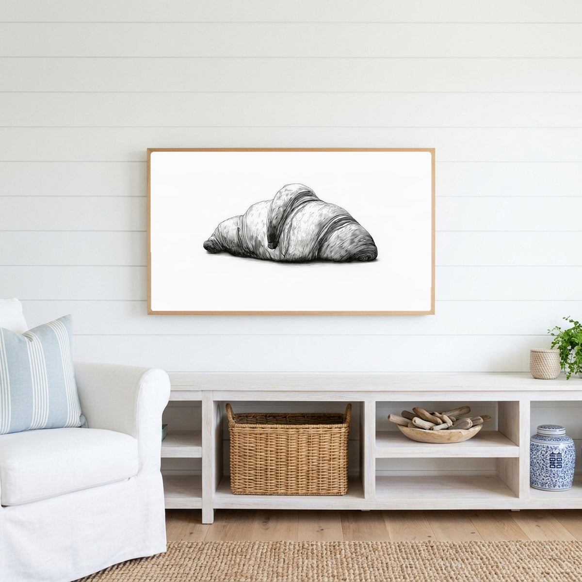 Croissant etching Frame TV art above a white console with a rattan basket in a coastal living room