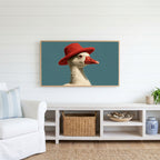 Duck in a red hat Frame TV art above a white console with a rattan basket in a coastal living room