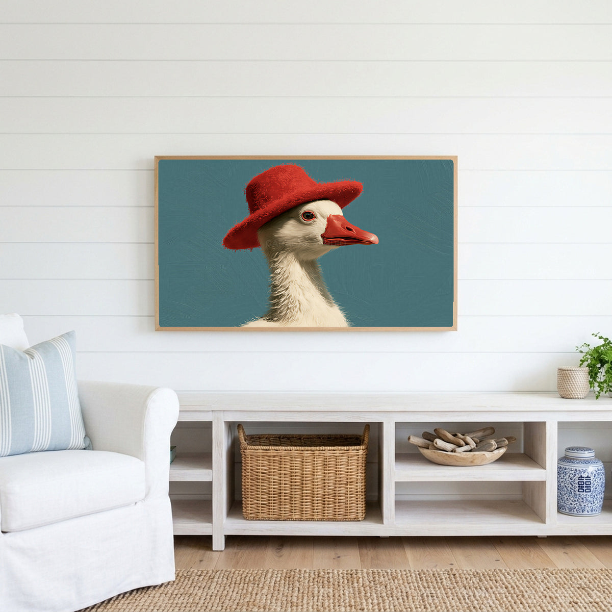 Duck in a red hat Frame TV art above a white console with a rattan basket in a coastal living room