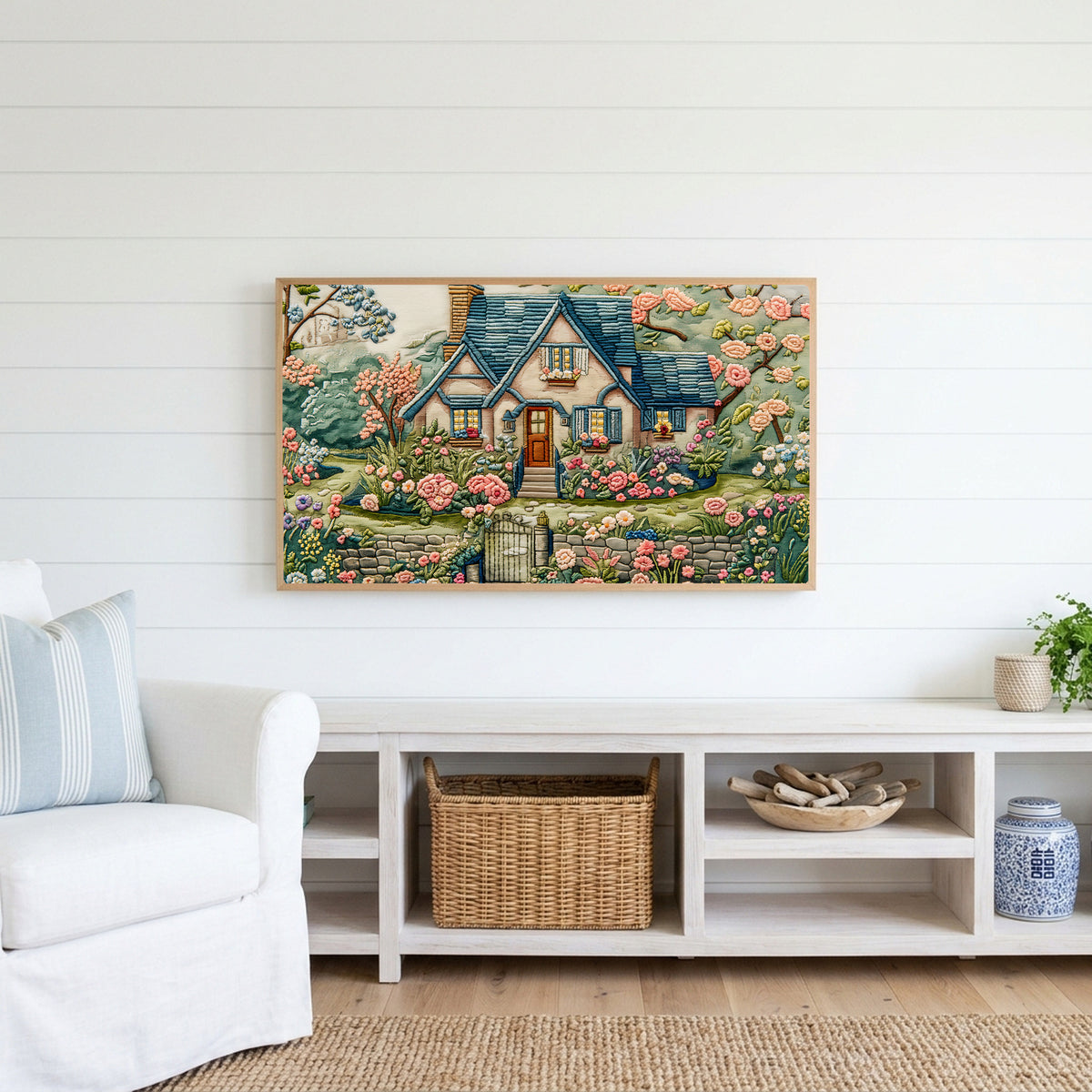 Embroidery style cottage Frame TV art above a white console with a rattan basket in a coastal living room