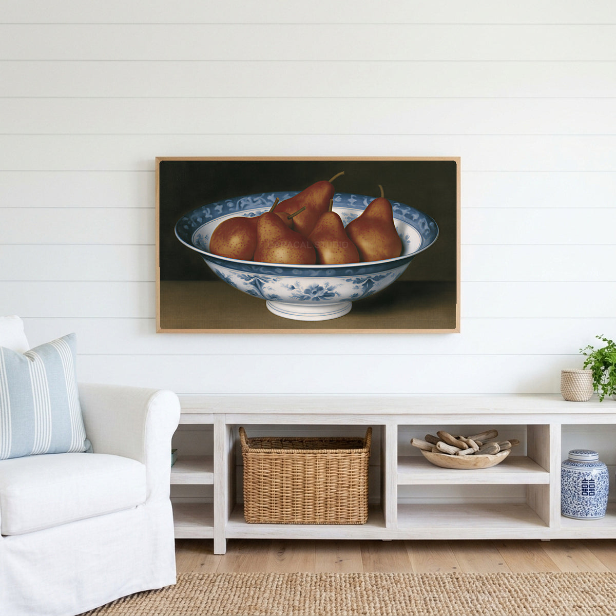 Pears in a porcelain bowl Frame TV art above a white console with a rattan basket in a coastal living room