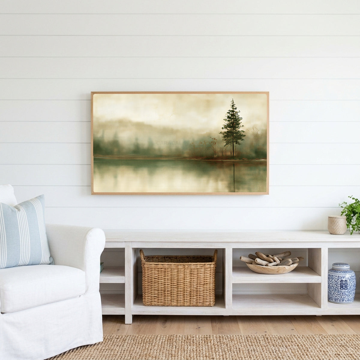 Misty lake pine Frame TV art above a white console with a rattan basket in a coastal living room