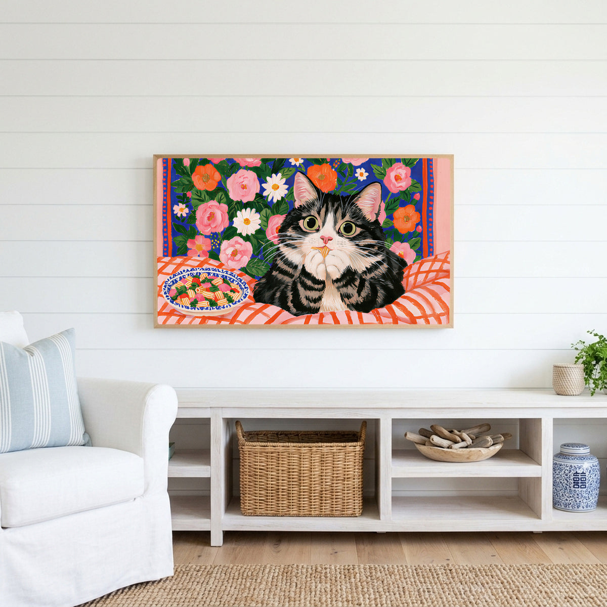Pasta cat Frame TV art above a white console with a rattan basket in a coastal living room