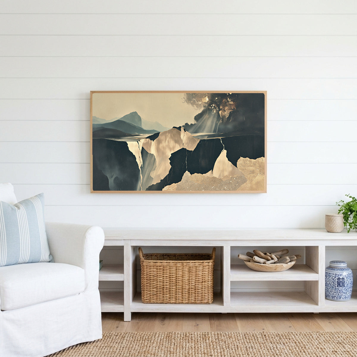 Moody abstract cliffs Frame TV art above a white console with a rattan basket in a coastal living room