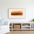 Terracotta brushstroke Frame TV art above a white console with a rattan basket in a coastal living room