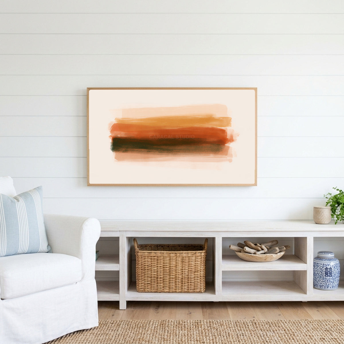 Terracotta brushstroke Frame TV art above a white console with a rattan basket in a coastal living room