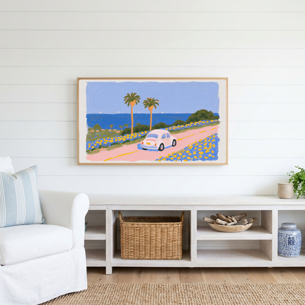 Seaside car Frame TV art above a white console with a rattan basket in a coastal living room