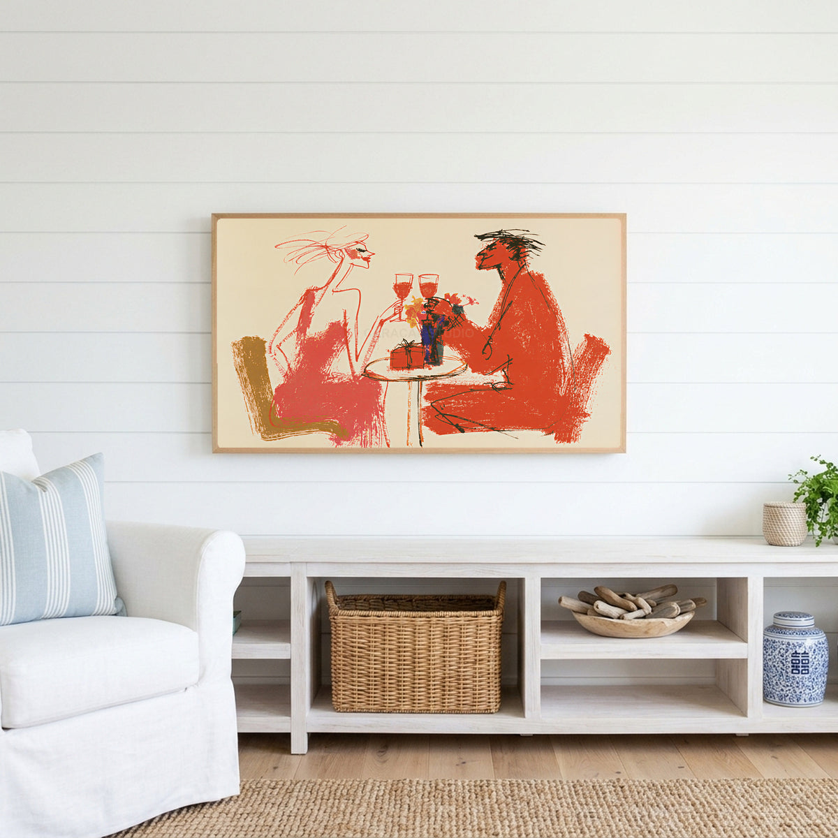 Wine toast Frame TV art above a white console with a rattan basket in a coastal living room