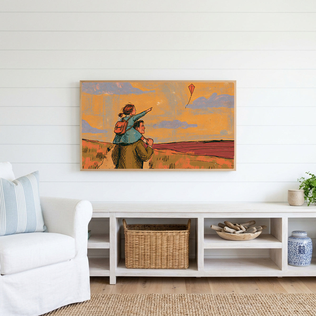 Father and daughter Frame TV art above a white console with a rattan basket in a coastal living room