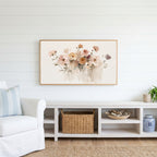 Soft wildflowers Frame TV art above a white console with a rattan basket in a coastal living room