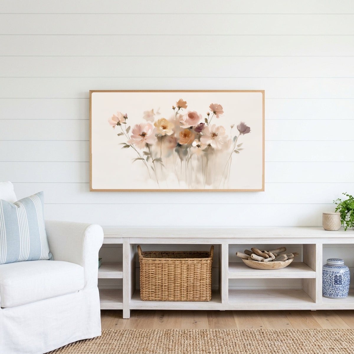 Soft wildflowers Frame TV art above a white console with a rattan basket in a coastal living room