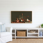 Wine and pomegranates still life Frame TV art above a white console with a rattan basket in a coastal living room