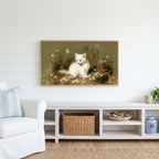 White kitten Frame TV art above a white console with a rattan basket in a coastal living room