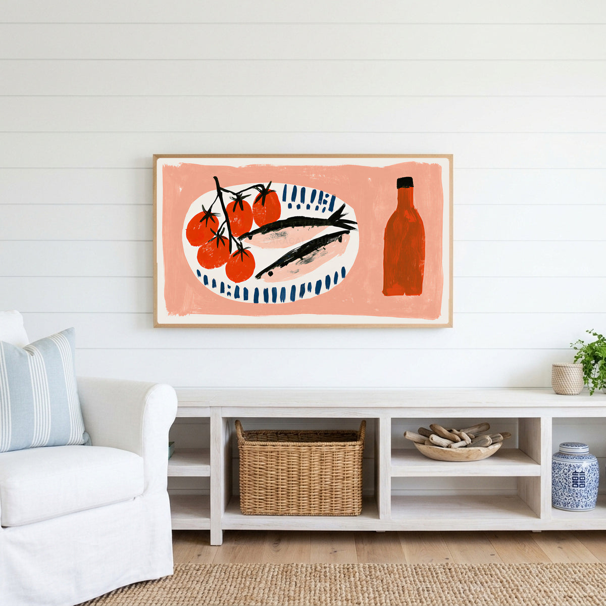 Sardines and tomatoes Frame TV art above a white console with a rattan basket in a coastal living room