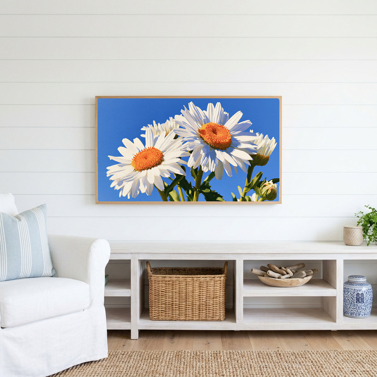Daisy Frame TV art above a white console with a rattan basket in a coastal living room