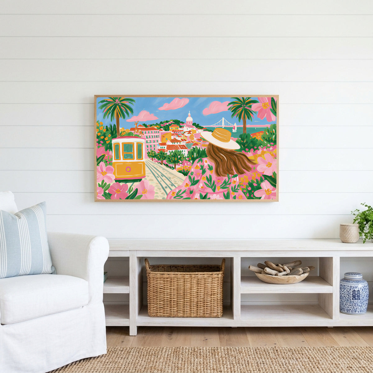 Lisbon tram Frame TV art above a white console with a rattan basket in a coastal living room