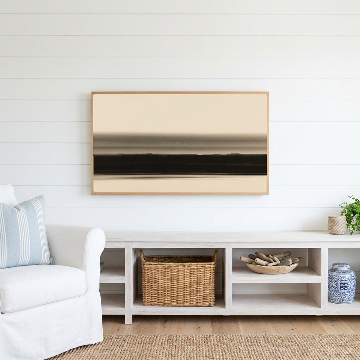Ink wash horizon Frame TV art above a white console with a rattan basket in a coastal living room