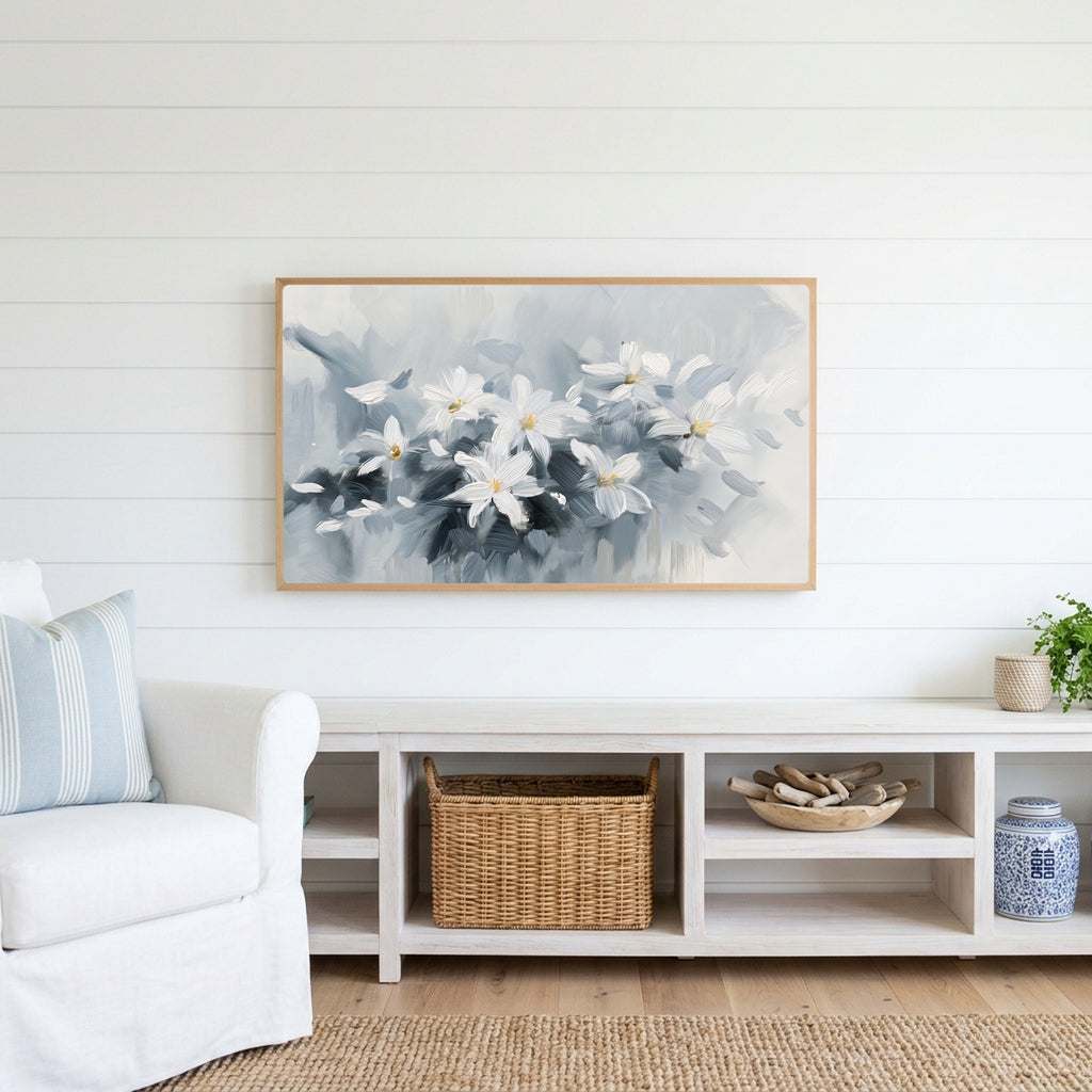 White flower Frame TV art above a white console with a rattan basket in a coastal living room