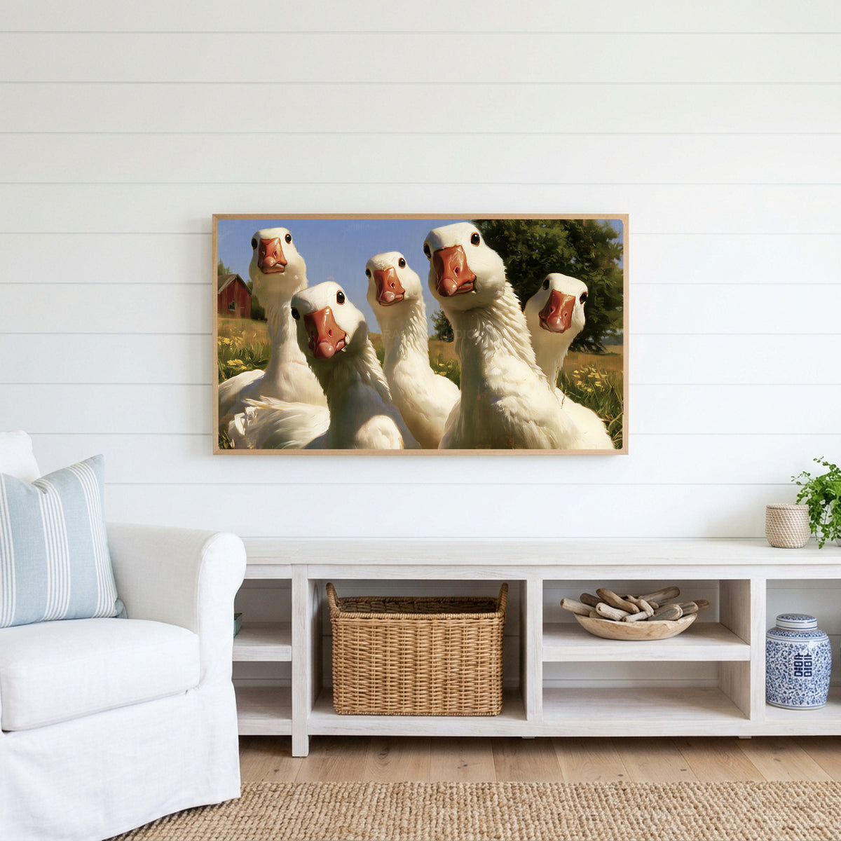 Curious white geese Frame TV art above a white console with a rattan basket in a coastal living room