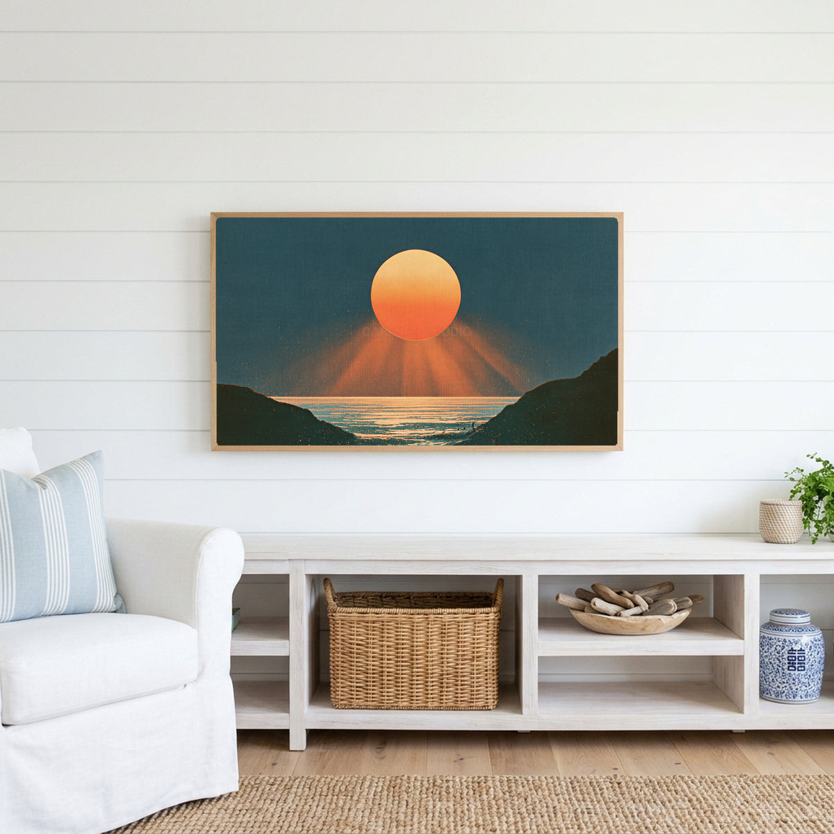 Ocean sunset Frame TV art above a white console with a rattan basket in a coastal living room