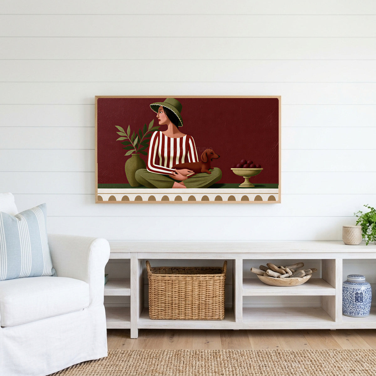 Woman with a dachshund Frame TV art above a white console with a rattan basket in a coastal living room
