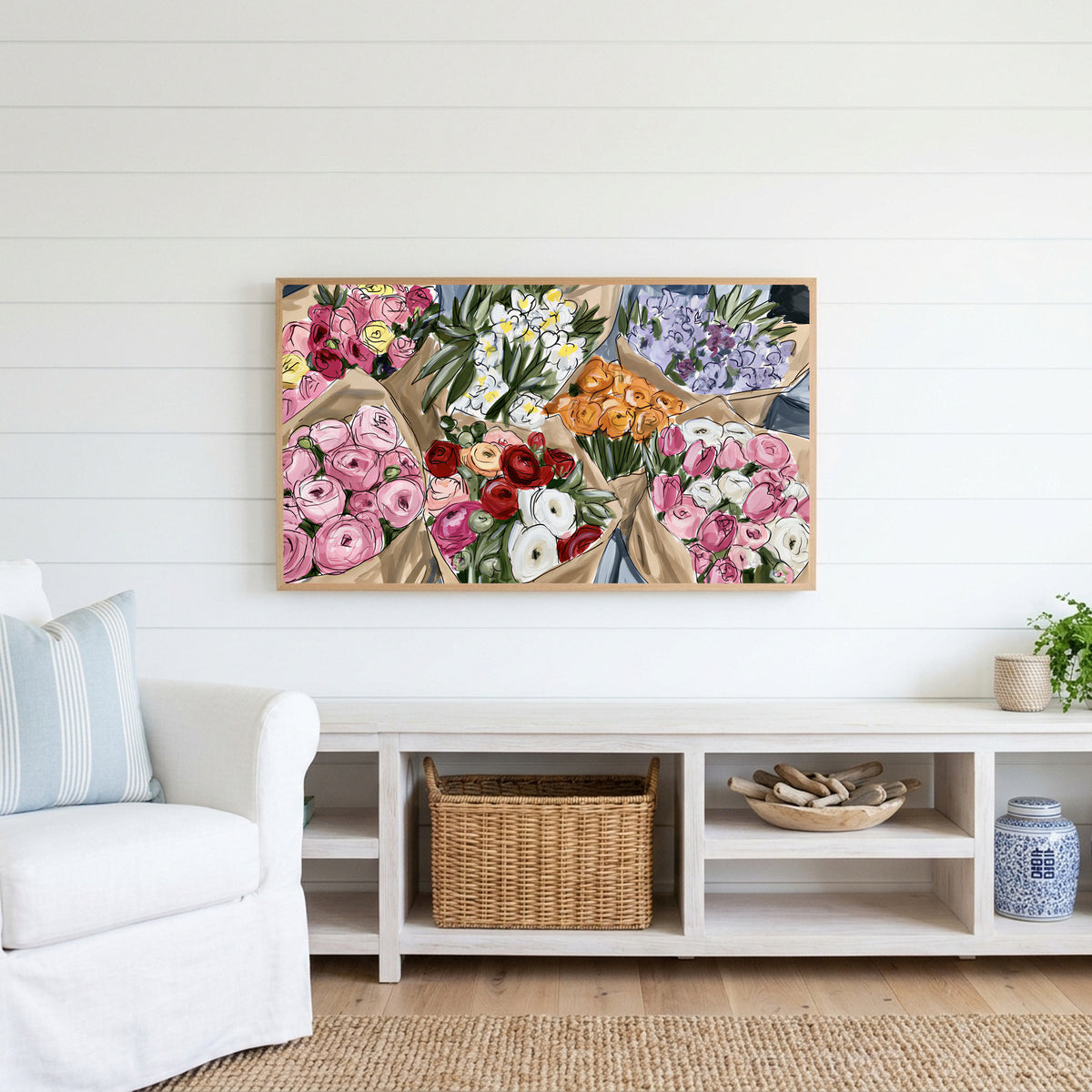Flower bouquets Frame TV art above a white console with a rattan basket in a coastal living room