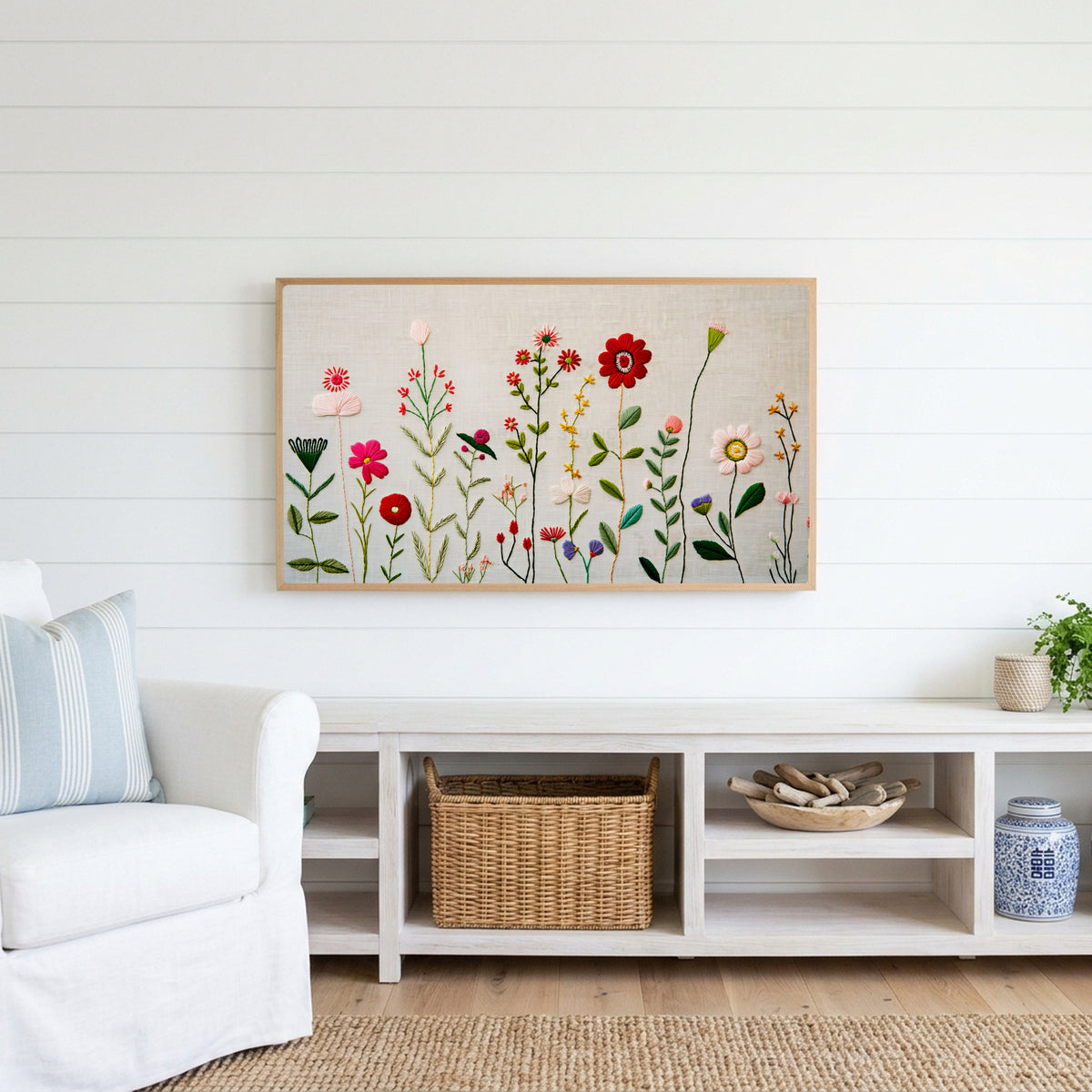 Embroidery style wildflower Frame TV art above a white console with a rattan basket in a coastal living room