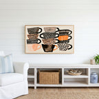 Stacked teacups Frame TV art above a white console with a rattan basket in a coastal living room