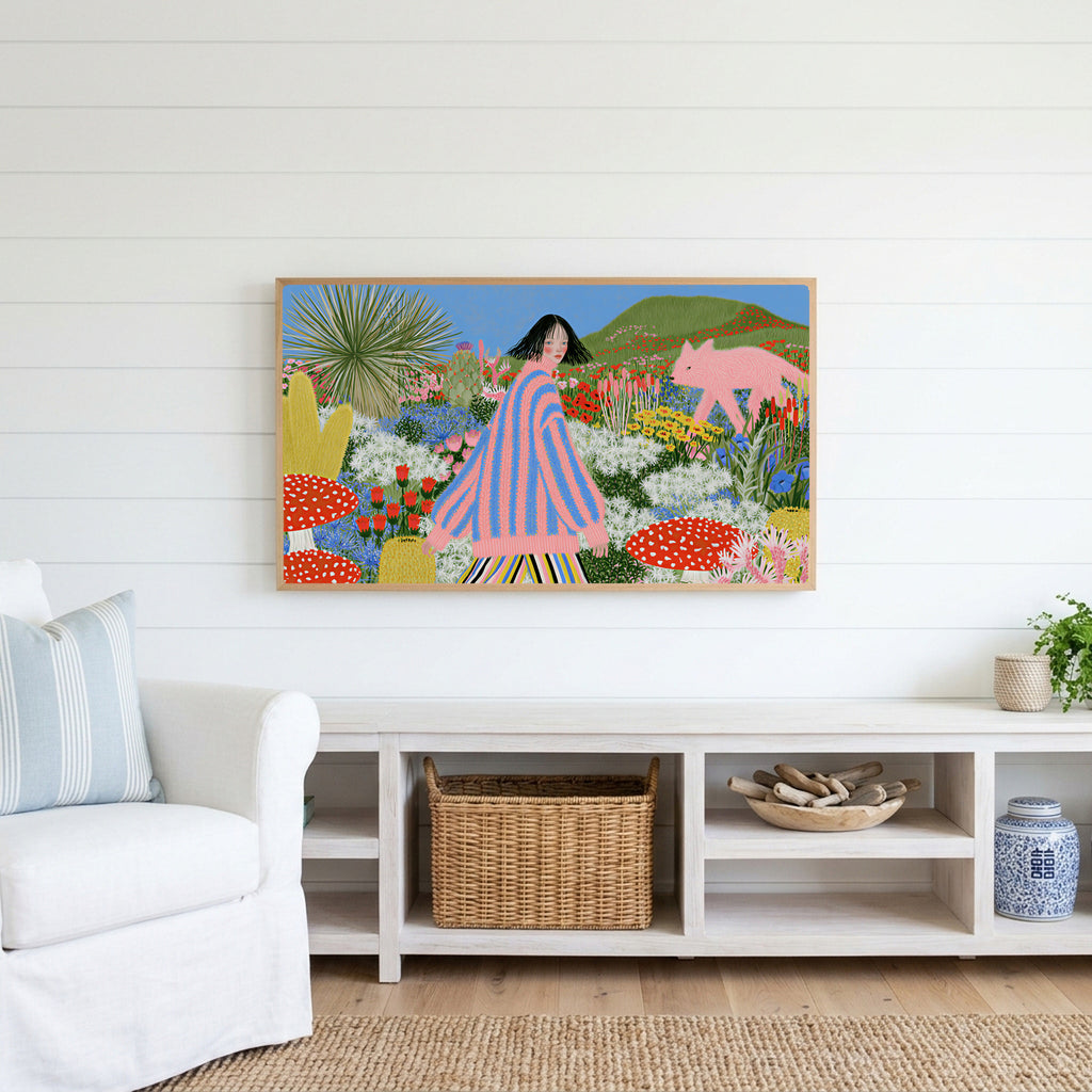 Flower garden and pink fox Frame TV art above a white console with a rattan basket in a coastal living room