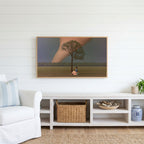 Storm field tree Frame TV art above a white console with a rattan basket in a coastal living room
