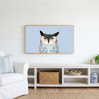 Grumpy owl Frame TV art above a white console with a rattan basket in a coastal living room
