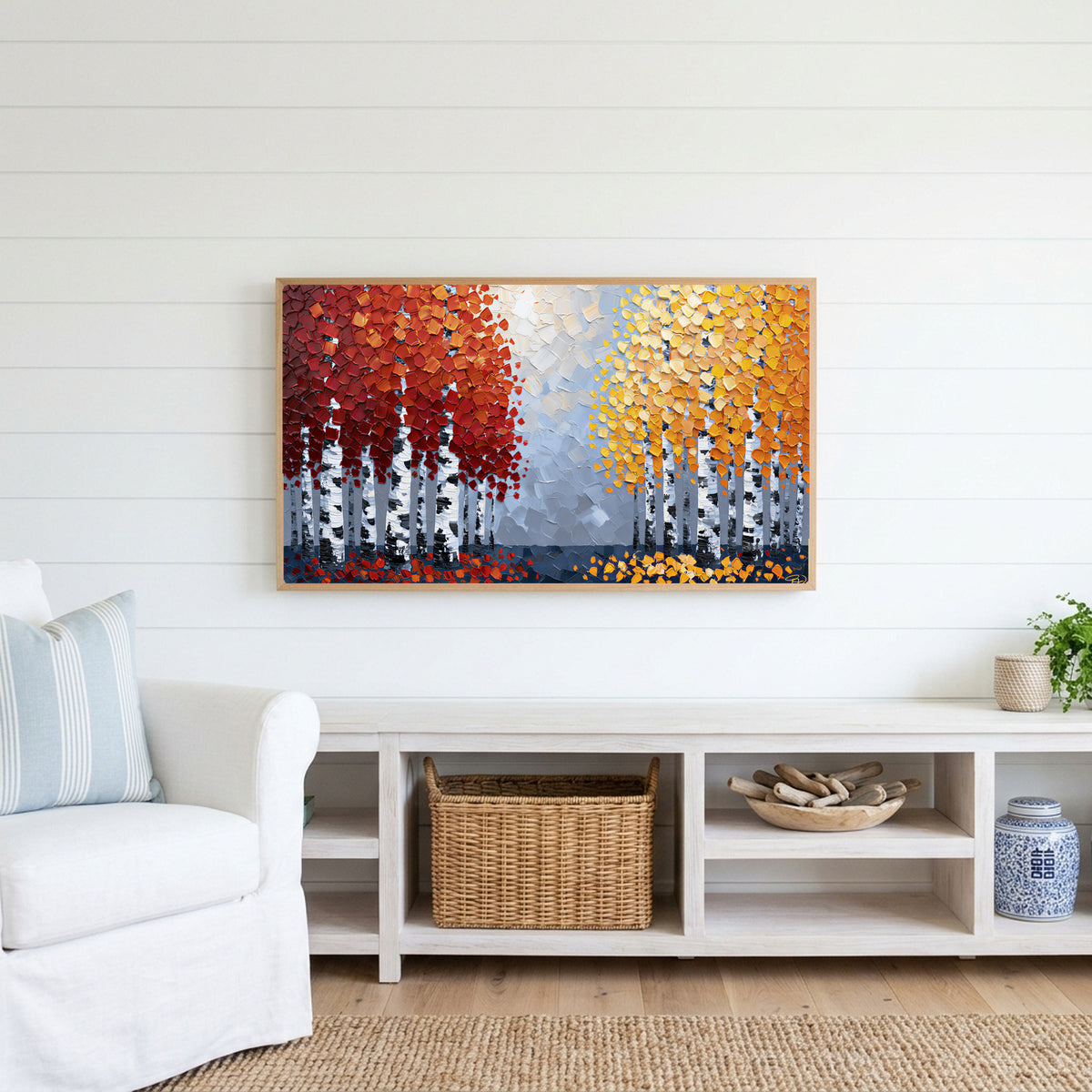 Autumn birch trees Frame TV art above a white console with a rattan basket in a coastal living room