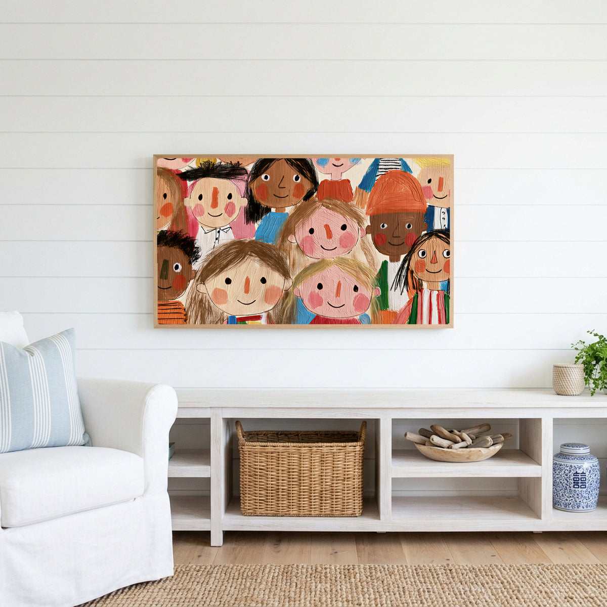 Smiling faces Frame TV art above a white console with a rattan basket in a coastal living room
