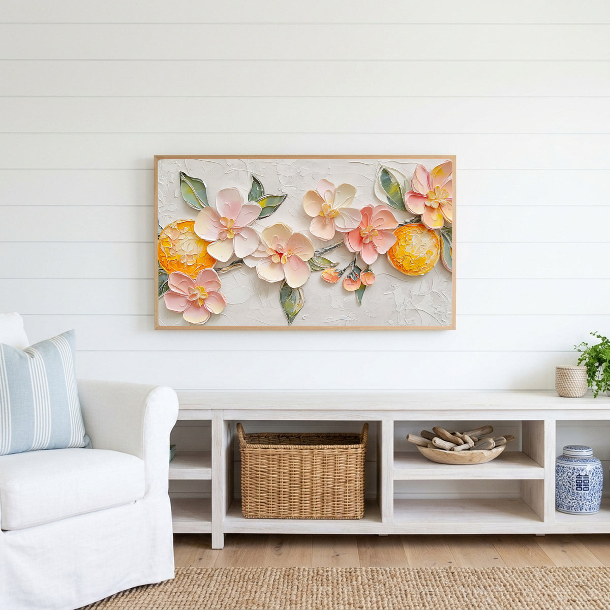 Blossom and orange Frame TV art above a white console with a rattan basket in a coastal living room