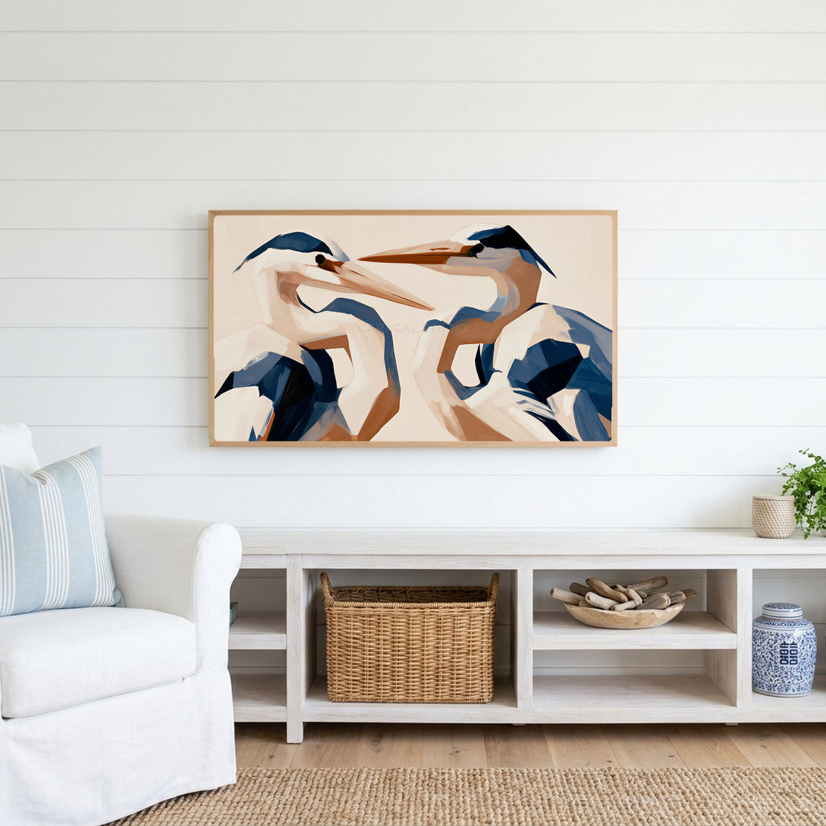 Blue heron Frame TV art above a white console with a rattan basket in a coastal living room