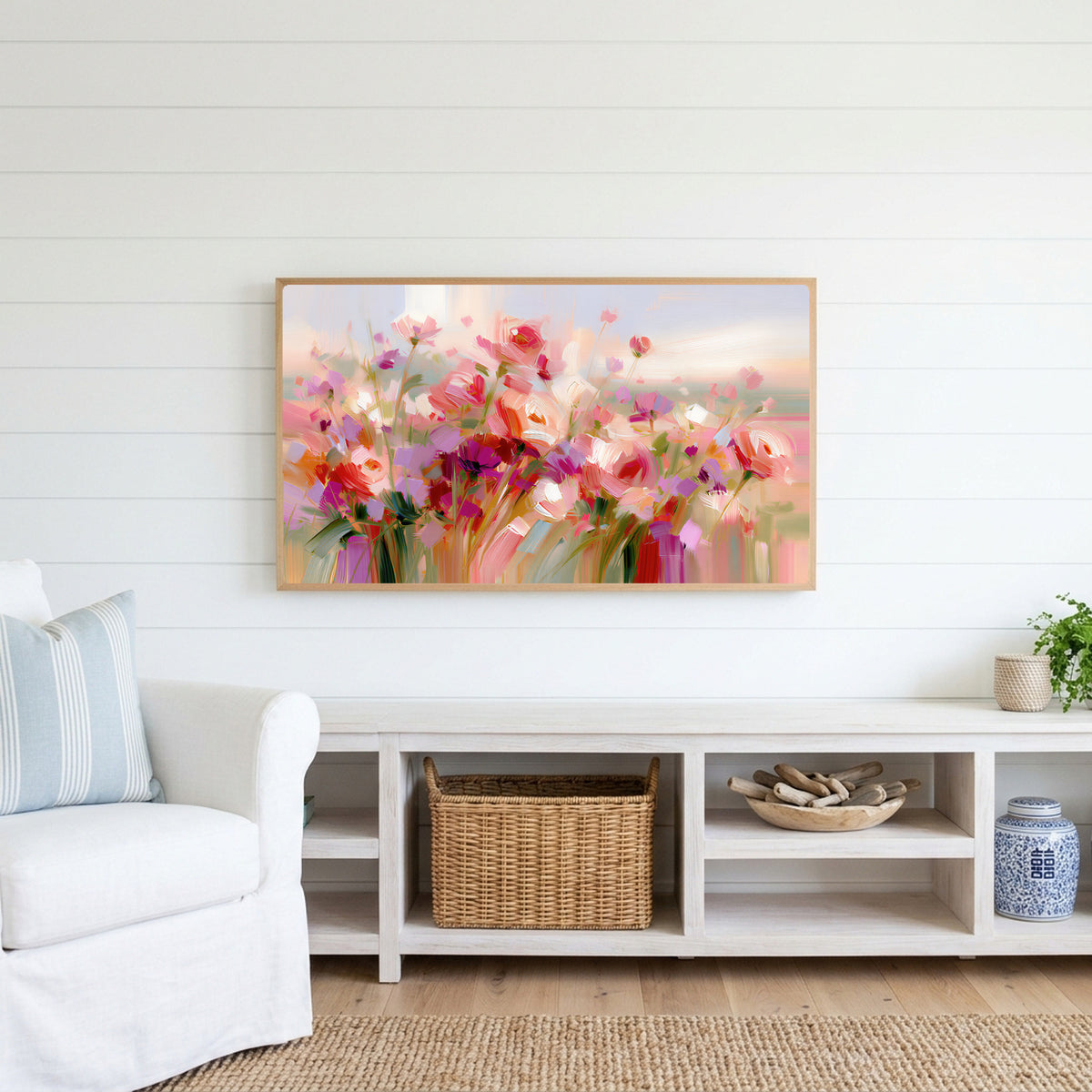 Pink wildflower meadow Frame TV art above a white console with a rattan basket in a coastal living room