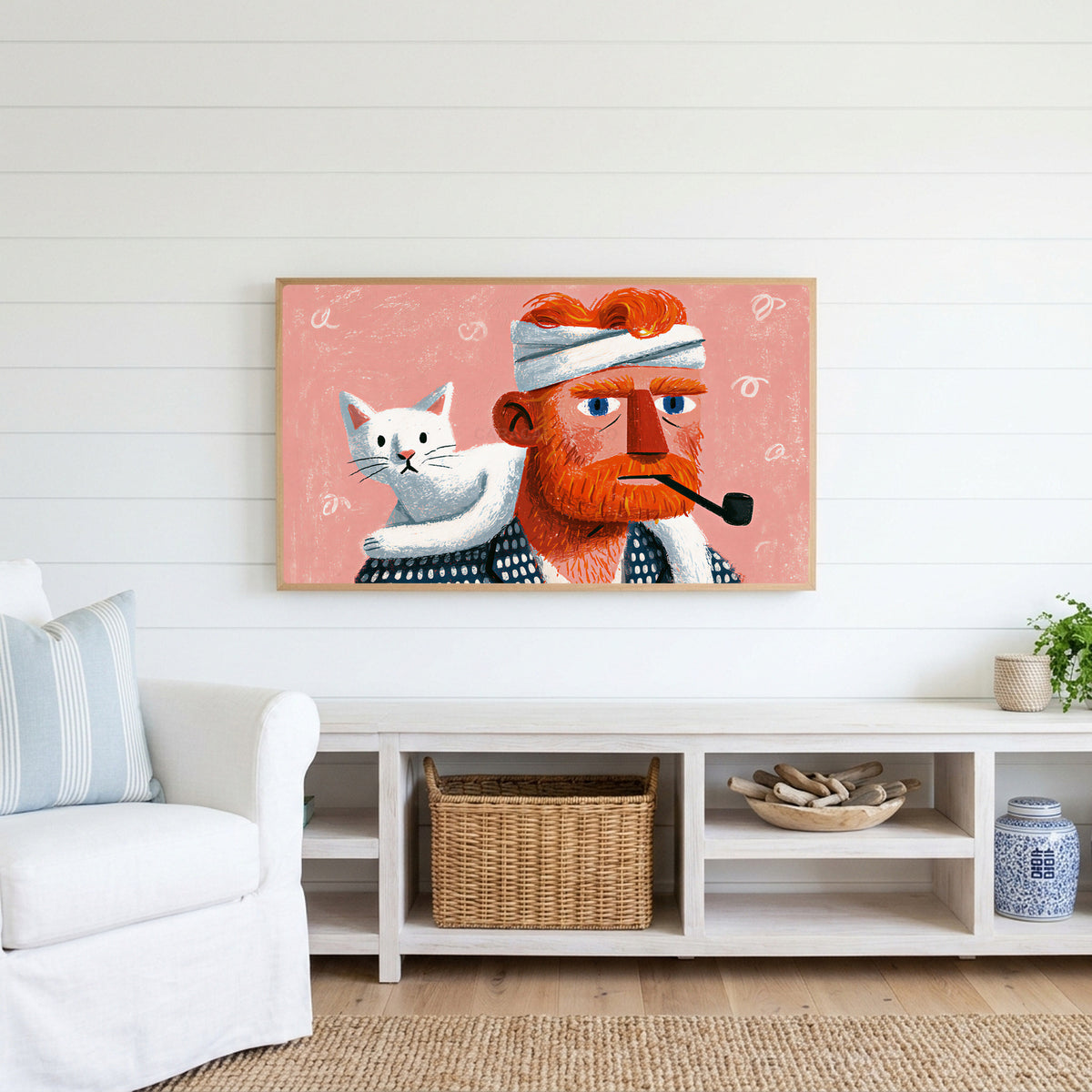 Bearded man and cat Frame TV art above a white console with a rattan basket in a coastal living room
