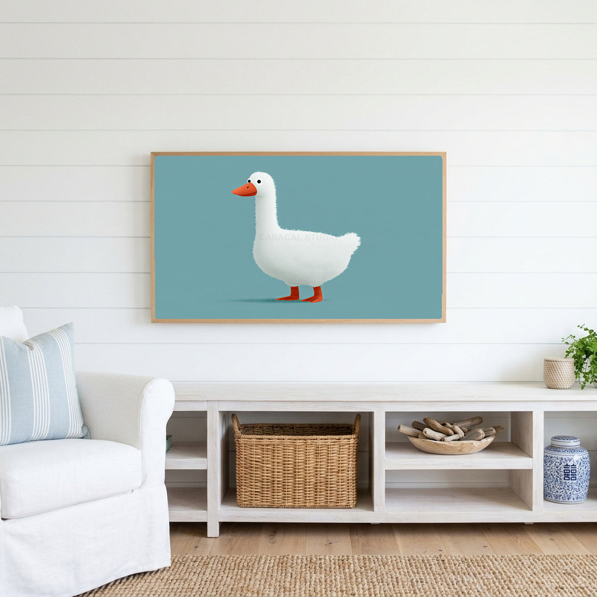 White duck Frame TV art above a white console with a rattan basket in a coastal living room