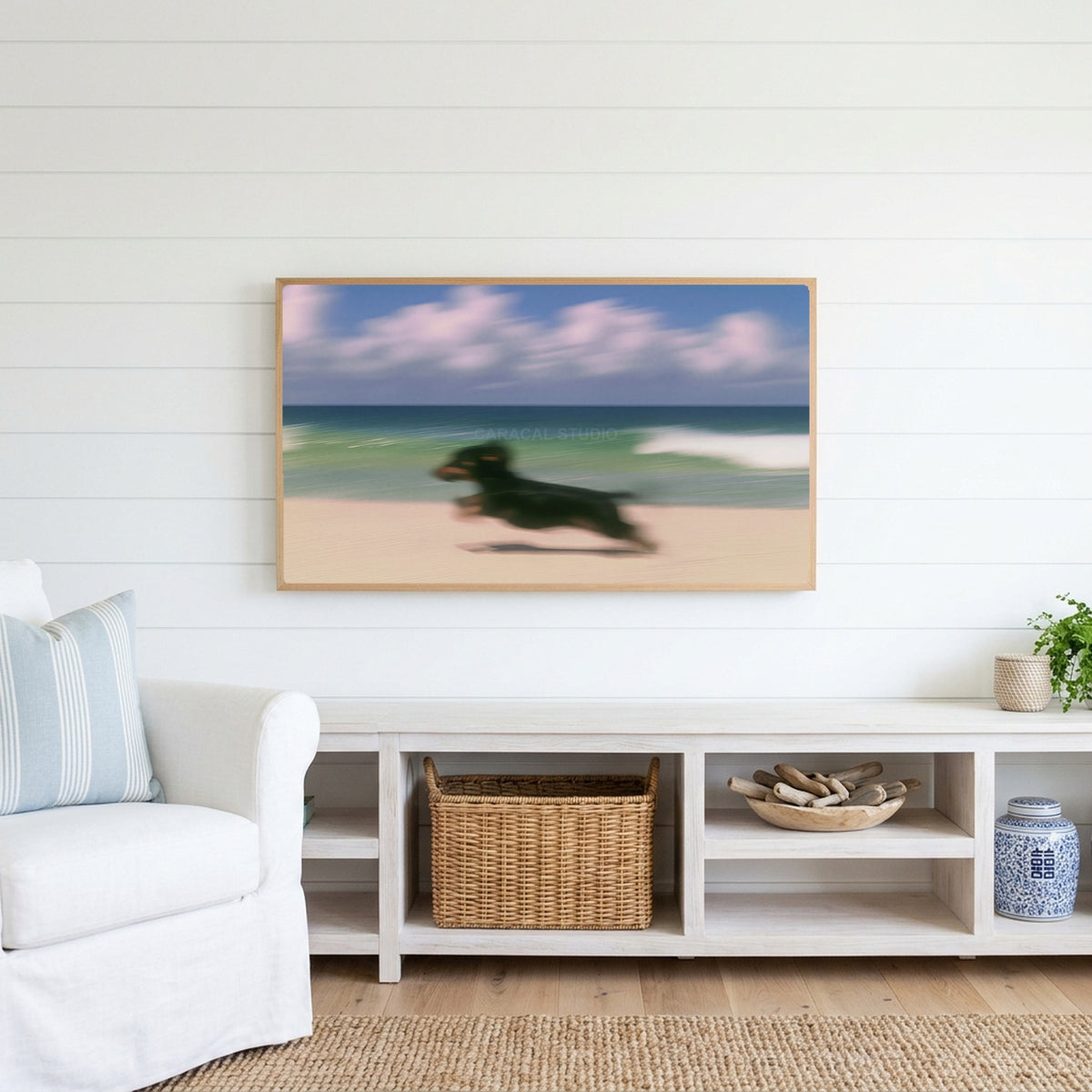 Running beach dachshund Frame TV art above a white console with a rattan basket in a coastal living room