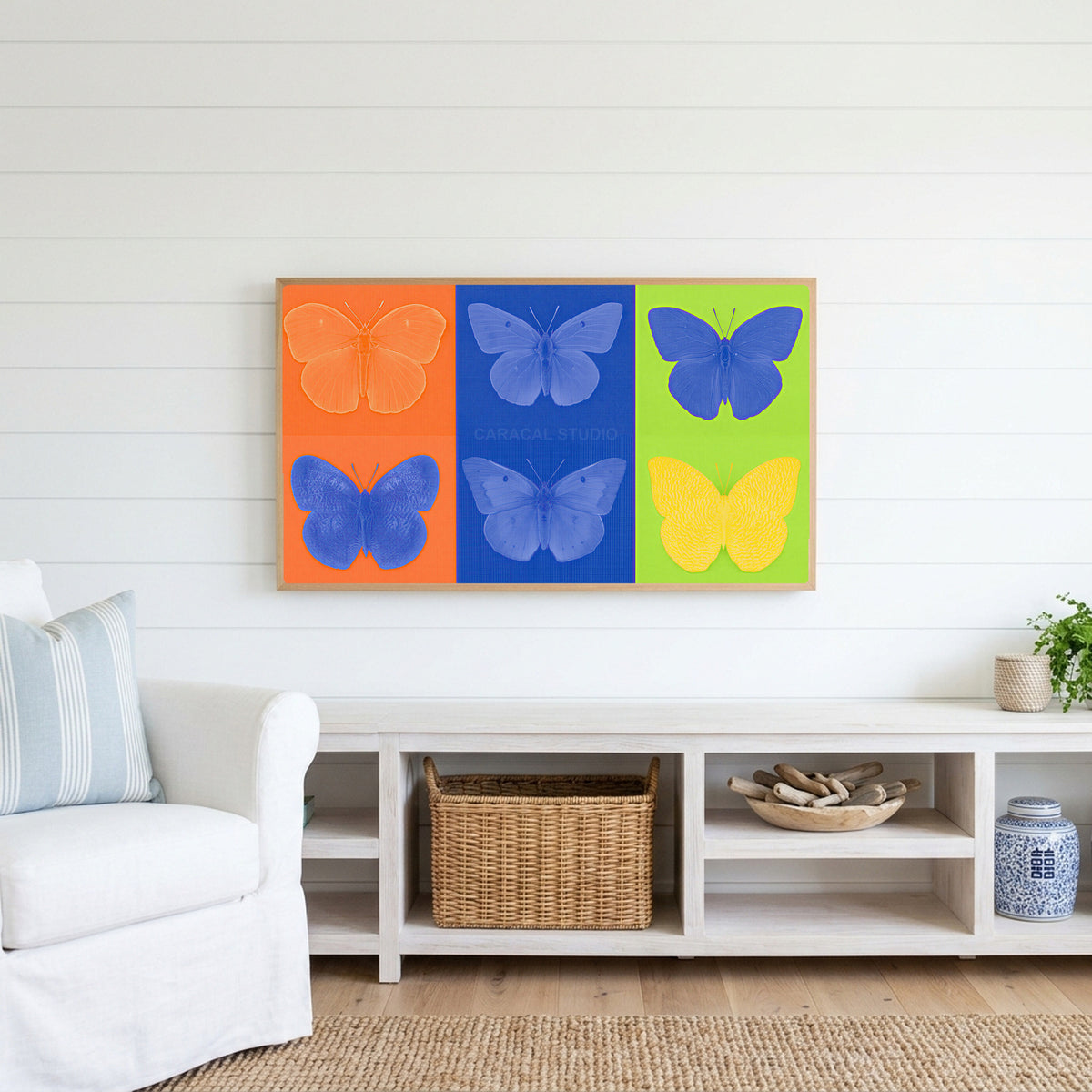 Pop art butterfly Frame TV art above a white console with a rattan basket in a coastal living room