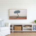 Mosaic tree Frame TV art above a white console with a rattan basket in a coastal living room