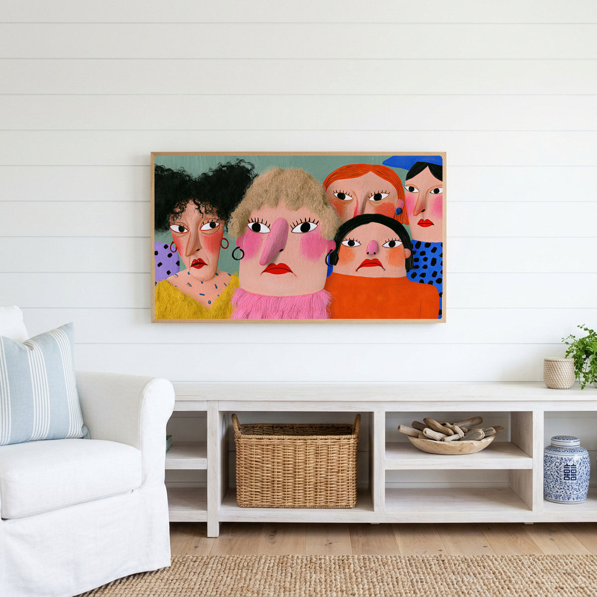 Funny faces portrait Frame TV art above a white console with a rattan basket in a coastal living room
