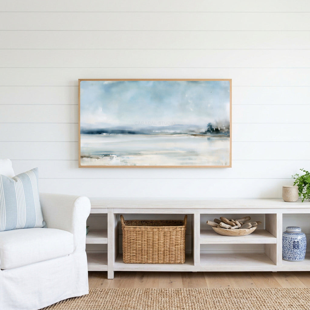 Snowy landscape Frame TV art above a white console with a rattan basket in a coastal living room