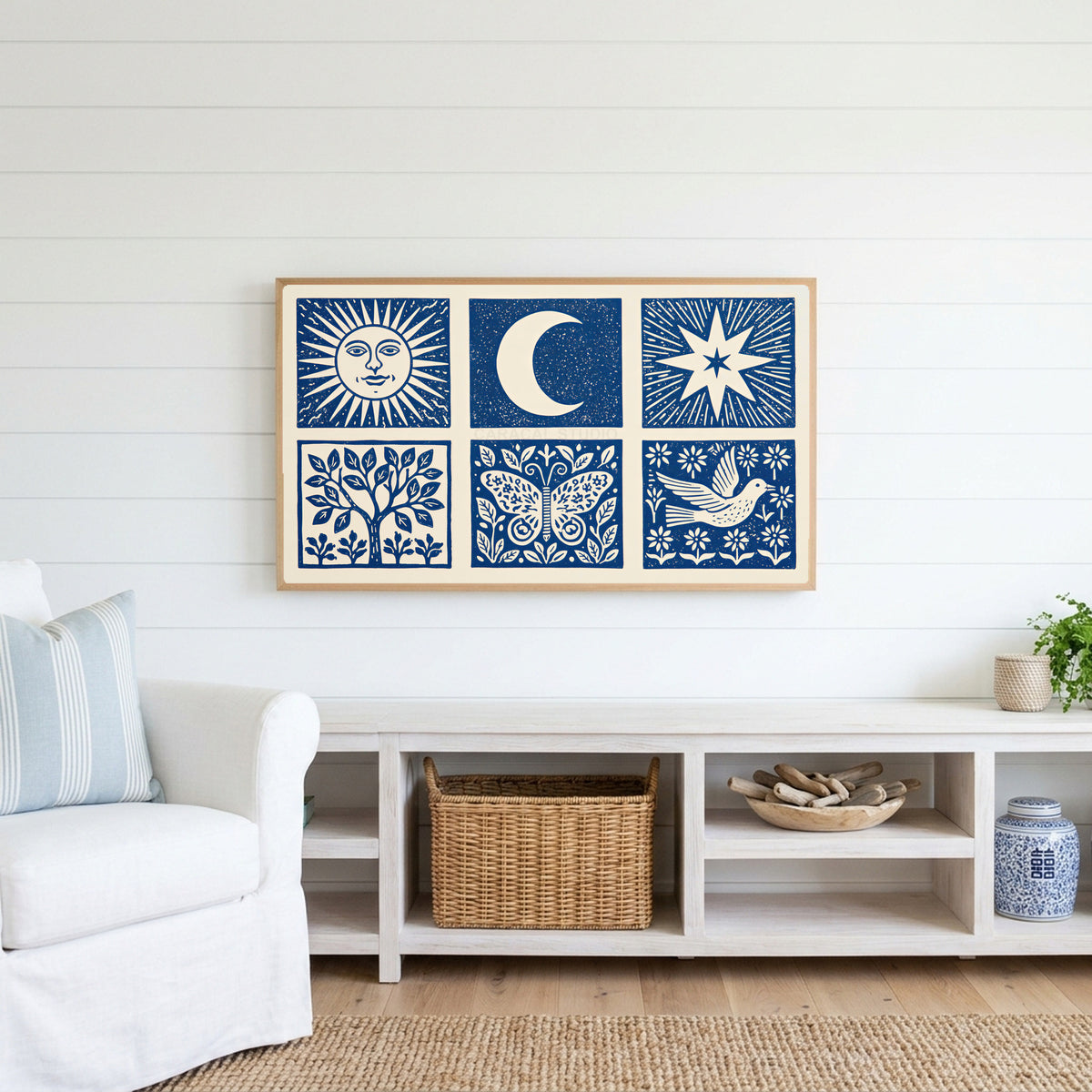 Celestial folk Frame TV art above a white console with a rattan basket in a coastal living room